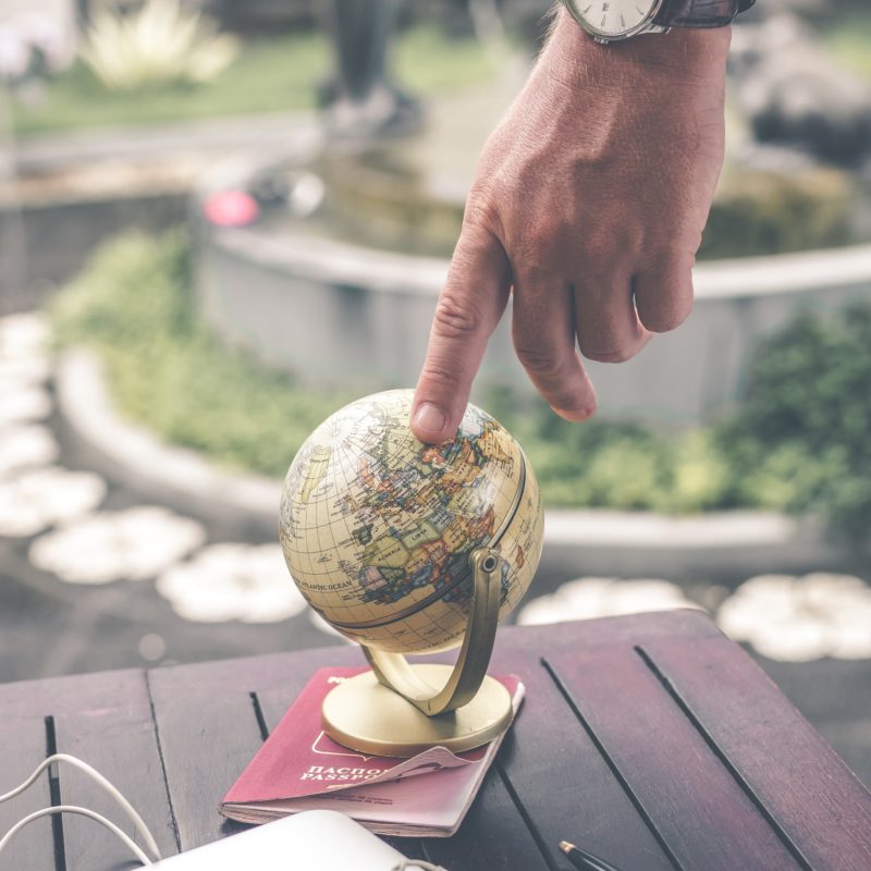 man touching miniature globe